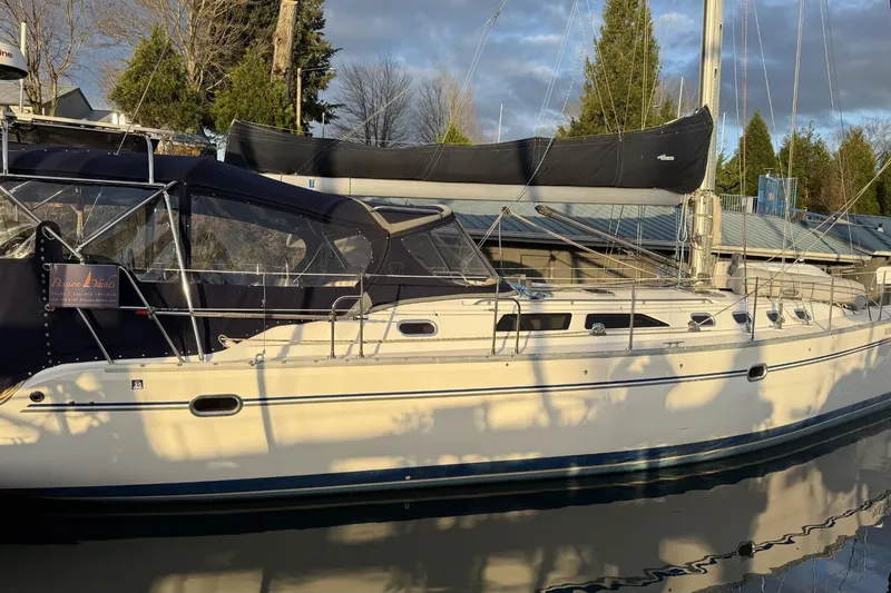 Slide: The Image of 2004 Catalina 470 sailboat docked, featuring sleek design and covered cockpit. - 52