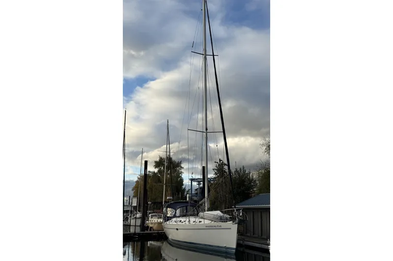 Slide: The Image of 2004 Catalina 470 sailboat docked under cloudy sky. - 56
