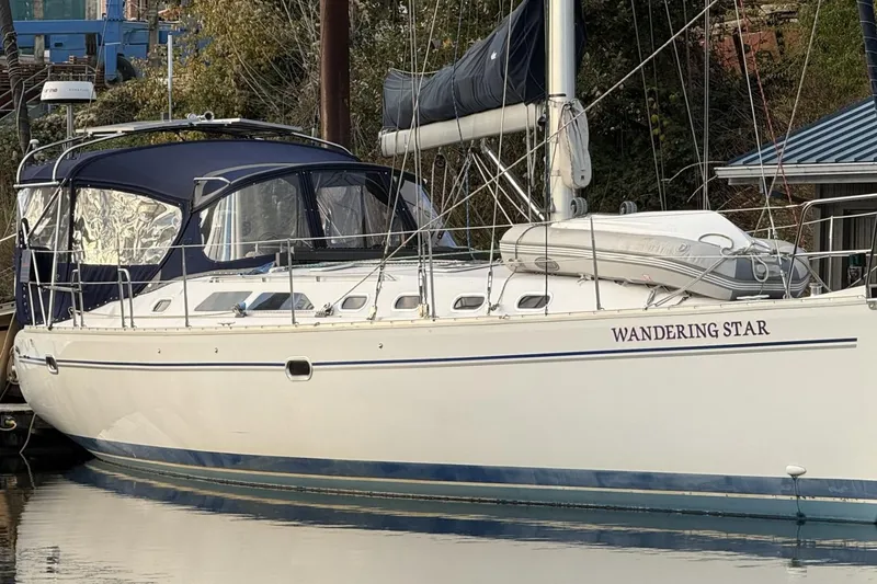 Slide: The Image of Catalina 470 sailboat named "Wandering Star" docked, 2004 model, with blue canopy. - 57