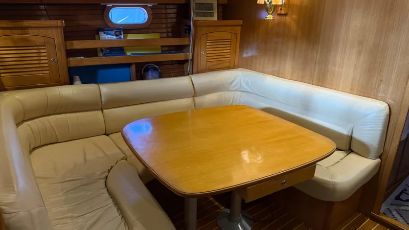 Slide: The Image of 2004 Catalina 470 yacht interior with cozy dining area and wooden table. - 6
