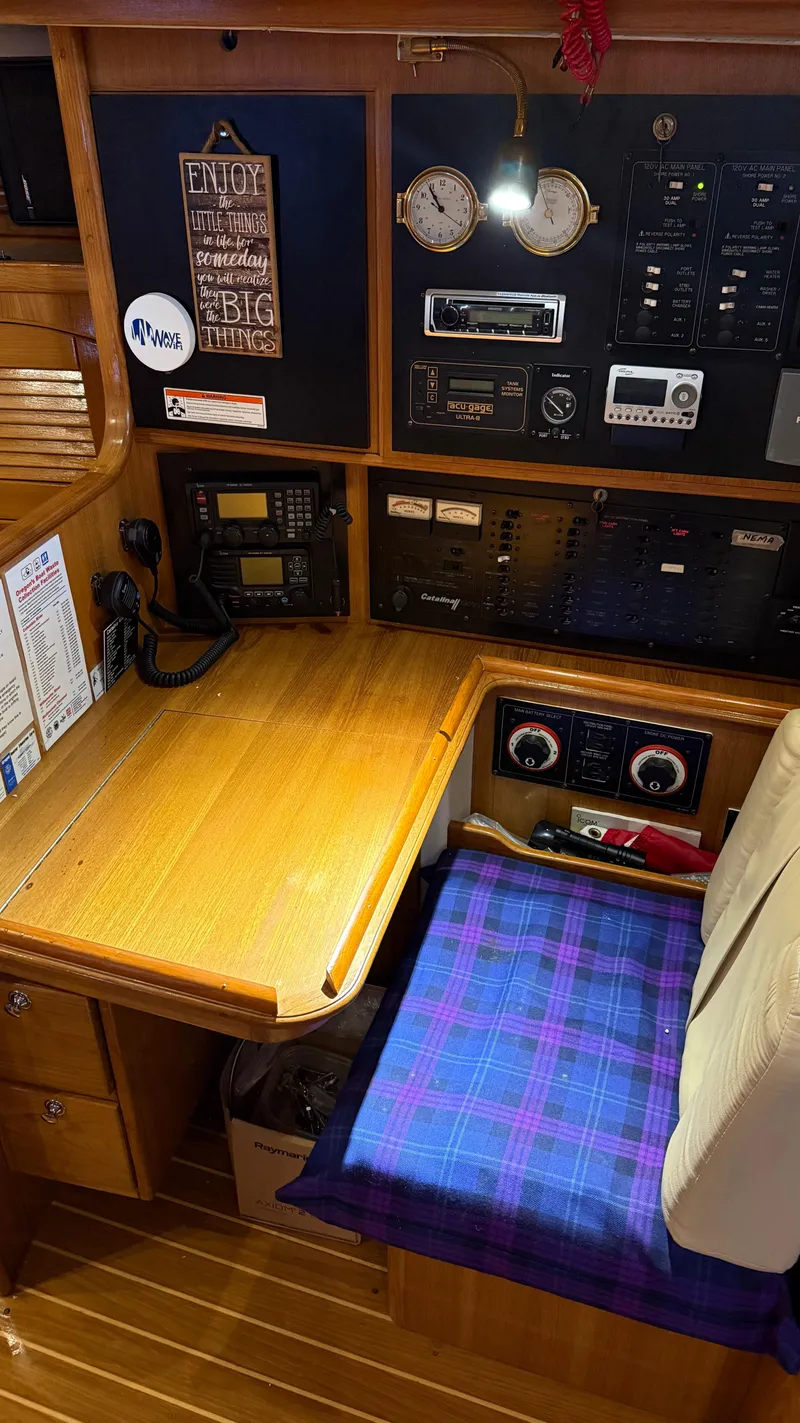Slide: The Image of Navigation station of a 2004 Catalina 470 sailboat with control panels and seating. - 7