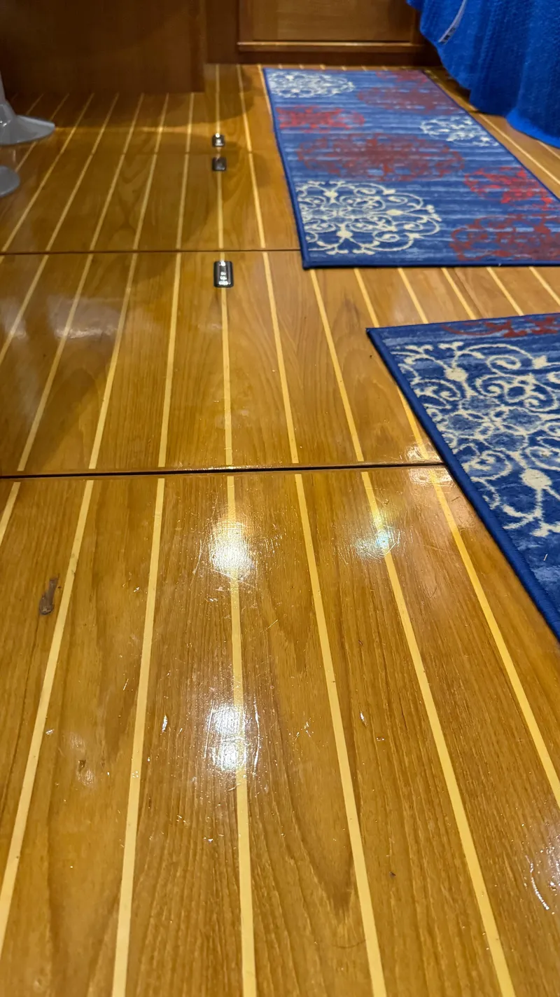 Slide: The Image of Polished wooden floor with blue patterned rugs on a 2004 Catalina 470 yacht. - 9