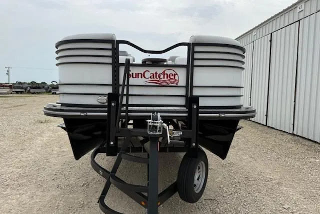Slide: The Image of 2025 SunCatcher ELITE 324RC boat trailer parked on gravel near a metal building. - 5