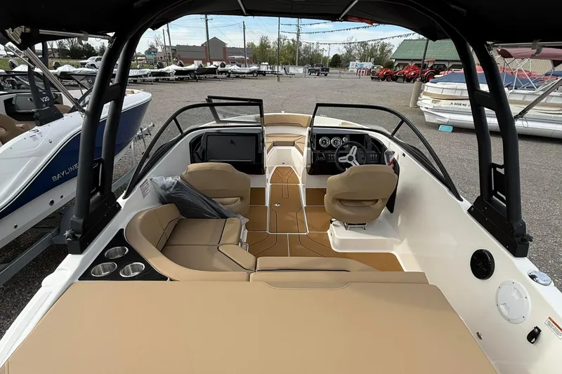Slide: The Image of 2026 Bayliner V20i boat interior with beige seating, steering console, and cup holders. - 5