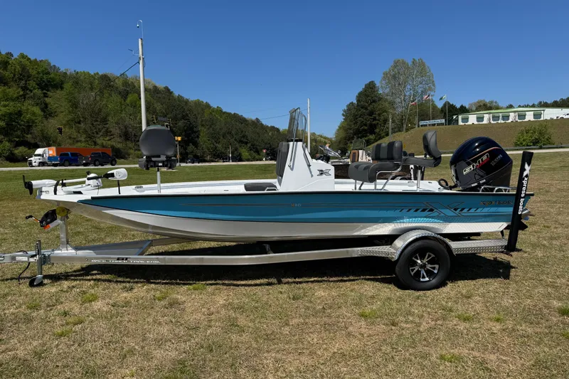 The Image of 2026 Xpress H20B Bay boat on trailer, parked on grass with trees in background. - 0