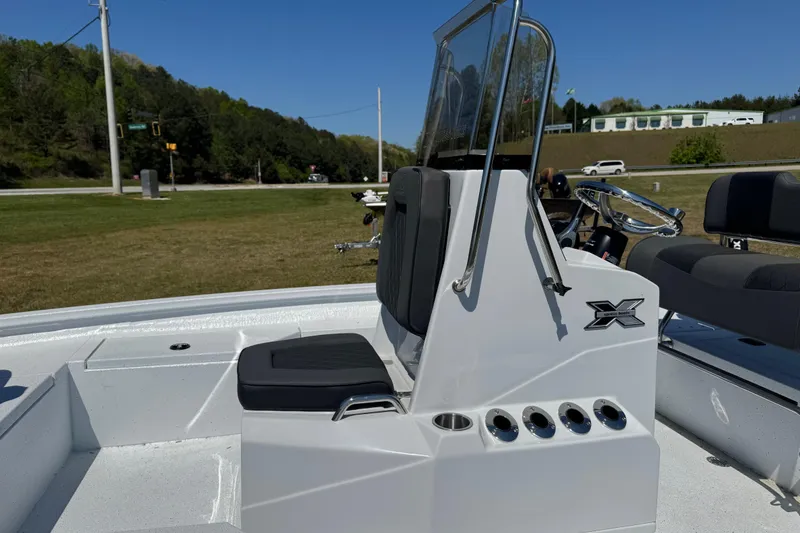 Slide: The Image of 2026 Xpress H20B Bay boat with sleek console and seating, parked outdoors. - 6