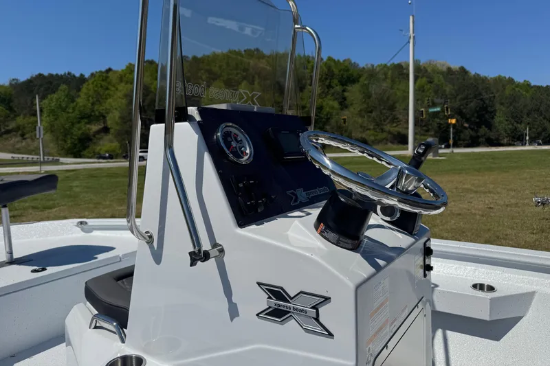 Slide: The Image of 2026 Xpress H20B Bay boat console with steering wheel and gauges, outdoors. - 7