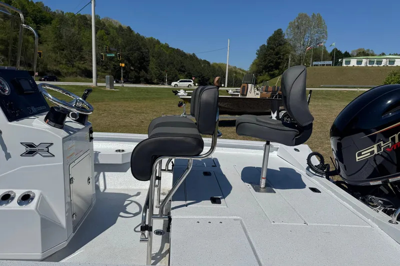 Slide: The Image of 2026 Xpress H20B Bay boat interior with seating and steering console, outdoors. - 8
