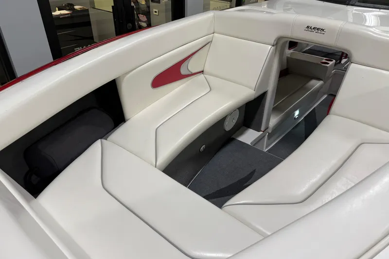 Slide: The Image of Interior of a 2004 Sleekcraft Enforcer 30 boat with white seating and red accents. - 10