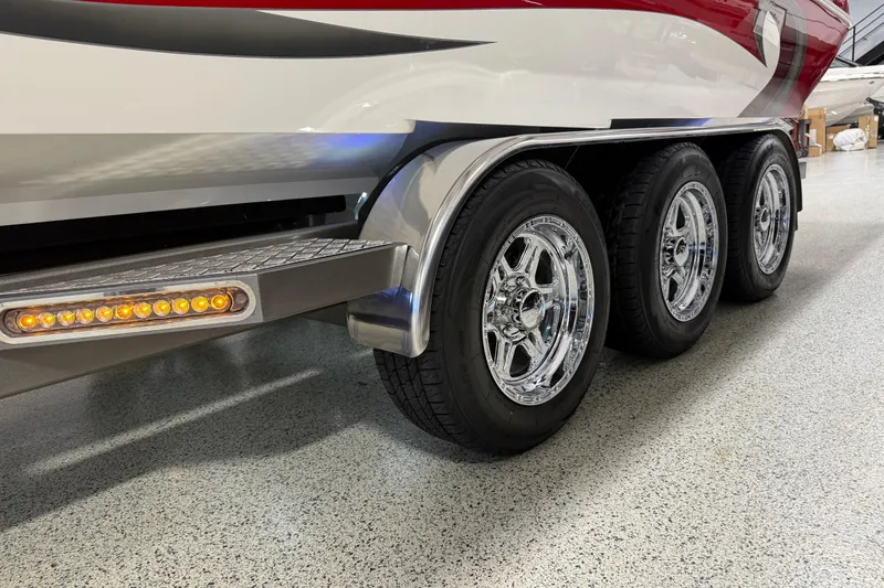 Slide: The Image of 2004 Sleekcraft Enforcer 30 boat trailer with triple chrome wheels and LED lights. - 2