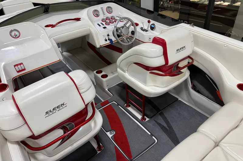Slide: The Image of 2004 Sleekcraft Enforcer 30 boat dashboard with chrome steering wheel and red-accented gauges. - 21