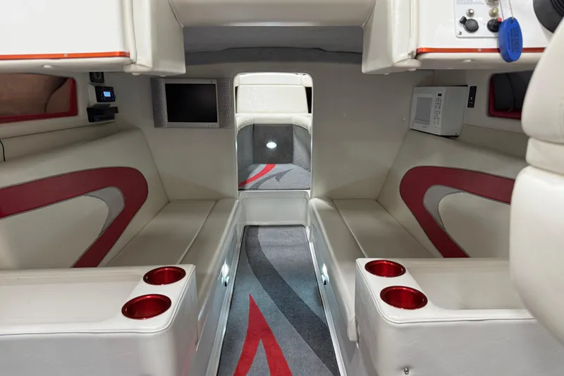 Slide: The Image of 2004 Sleekcraft Enforcer 30 boat interior with white and red seating in a garage setting. - 25