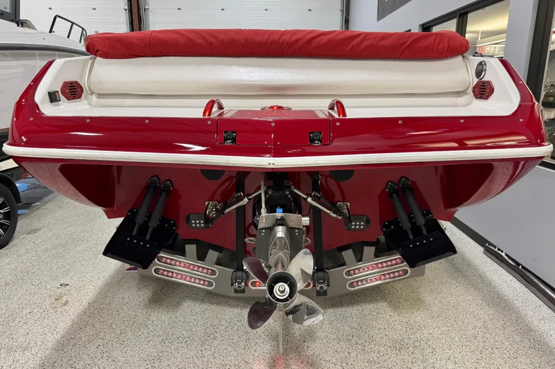 Slide: The Image of Red 2004 Sleekcraft Enforcer 30 boat rear view, showcasing propeller and trim tabs. - 5