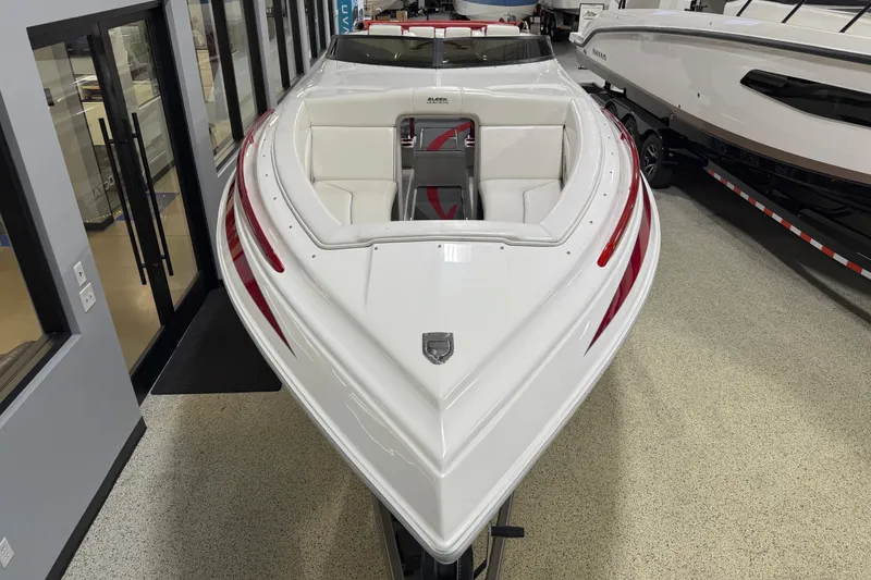 Slide: The Image of 2004 Sleekcraft Enforcer 30 boat with sleek white design and red accents in showroom. - 8