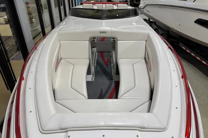 Slide: The Image of 2004 Sleekcraft Enforcer 30 boat with white seating and red accents in showroom. - 9