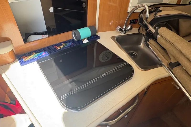 Slide: The Image of 2001 Bayliner 2655 Ciera interior with sink, stove, and countertop accessories. - 12