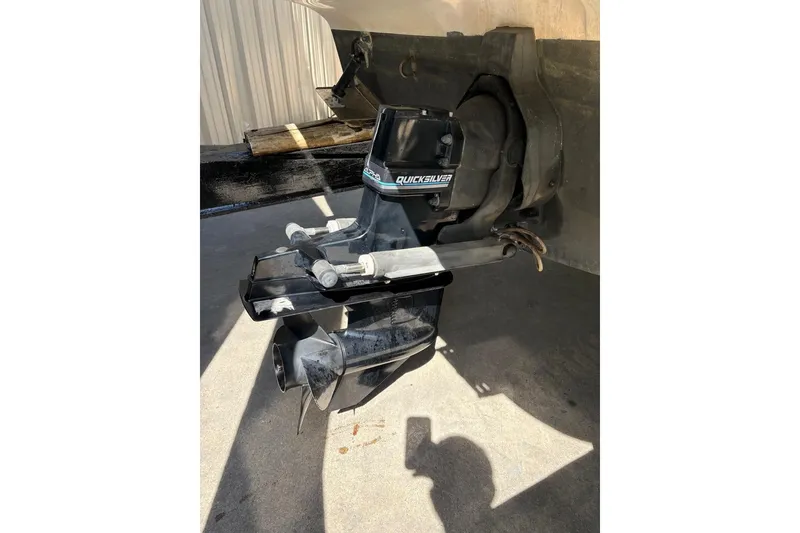 Slide: The Image of 2001 Bayliner 2655 Ciera boat outdrive, featuring Quicksilver branding, in a sunlit setting. - 19