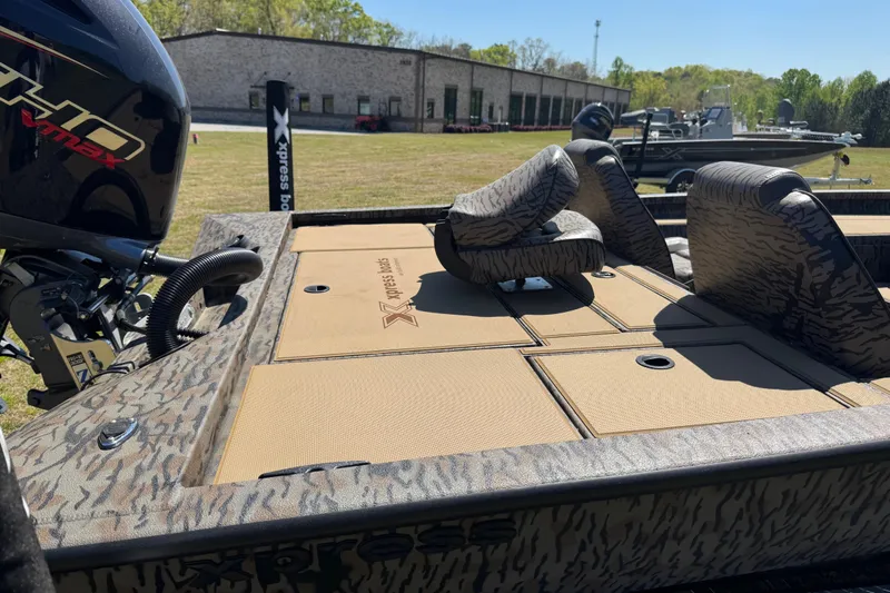 Slide: The Image of 2026 Xpress H20 Bass boat with camo seats and powerful outboard motor. - 10