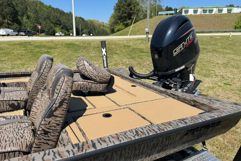 Slide: The Image of 2026 Xpress H20 Bass boat with camo seats and powerful outboard motor. - 7