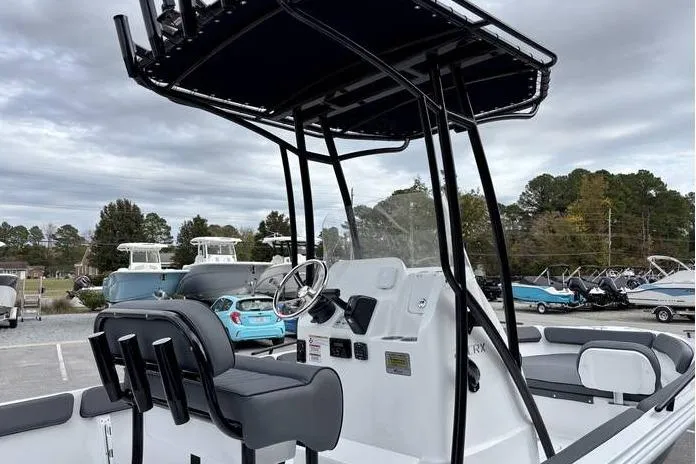 Slide: The Image of ```json { "alt_text": "2026 ALK2 23CRX boat with steering console and seating, parked outdoors." } ``` - 13