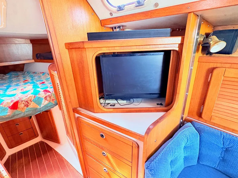 Slide: The Image of Interior of a 2001 Catalina 36 Mark II yacht with wood furnishings and TV. - 17