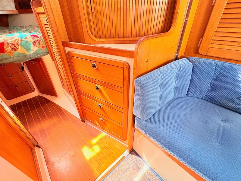 Slide: The Image of Interior of a 2001 Catalina 36 Mark II yacht with wood furnishings and blue upholstery. - 18