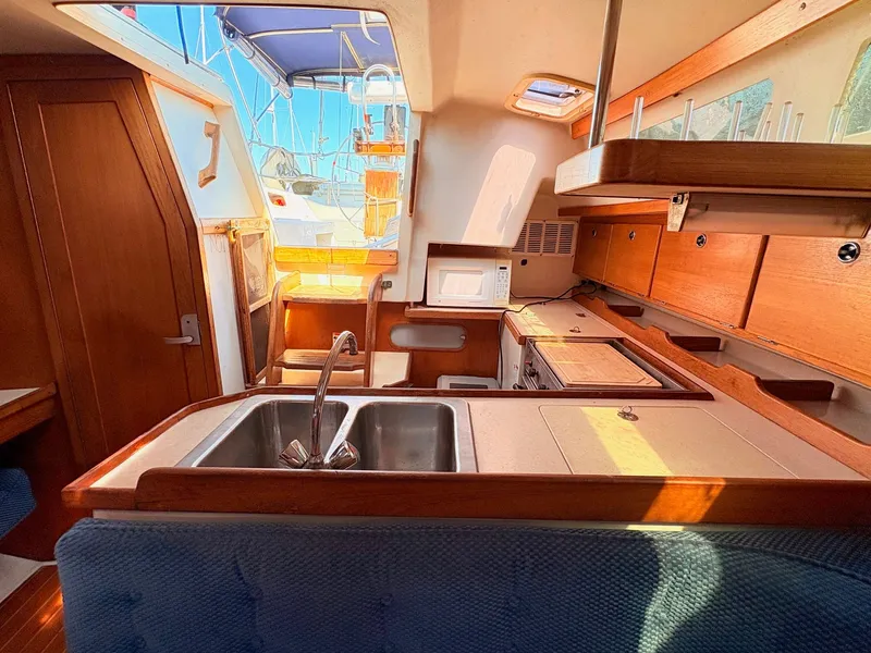 Slide: The Image of Interior of a 2001 Catalina 36 Mark II yacht with kitchen and wood paneling. - 27
