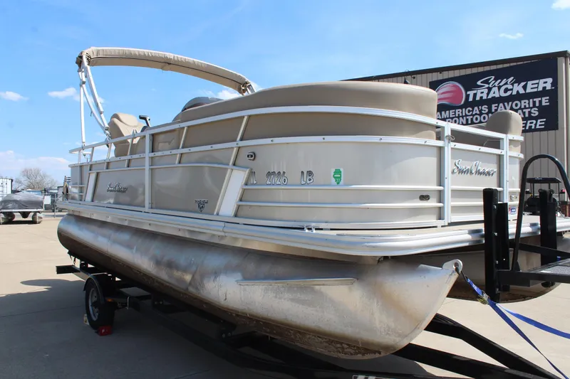 Slide: The Image of 2020 SunChaser Geneva Fish 20 4.0 pontoon boat on trailer, displayed outdoors. - 2