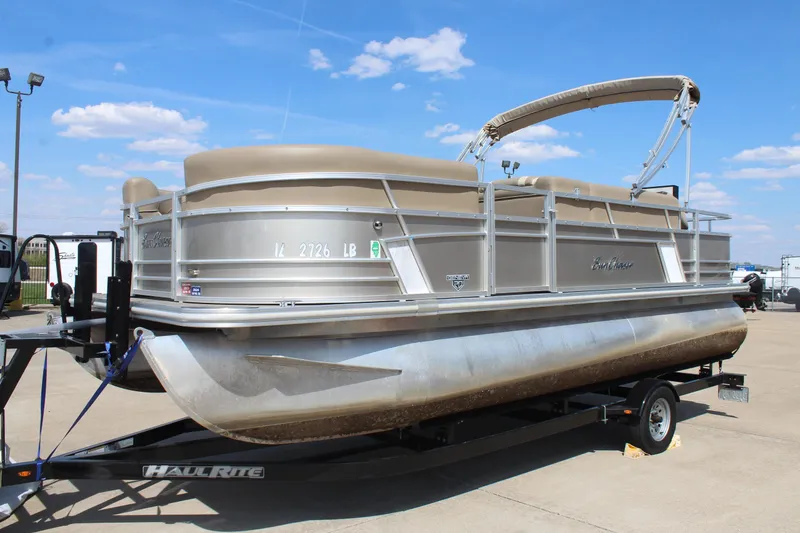 Slide: The Image of 2020 SunChaser Geneva Fish 20 4.0 pontoon boat on trailer under blue sky. - 4
