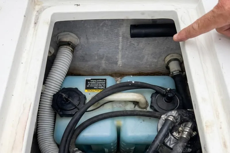 Slide: The Image of 1989 Grady-White Offshore 242 boat compartment with hoses and a blue tank. - 12