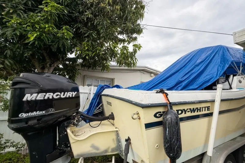 Slide: The Image of 1989 Grady-White Offshore 242 boat with Mercury OptiMax engine, covered with blue tarp. - 14