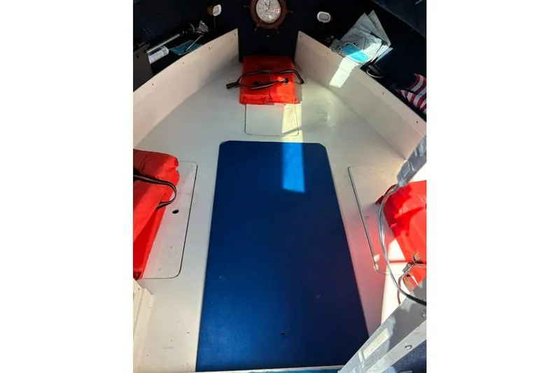 Slide: The Image of Interior of a 1989 Grady-White Offshore 242 boat with red cushions and blue mat. - 5