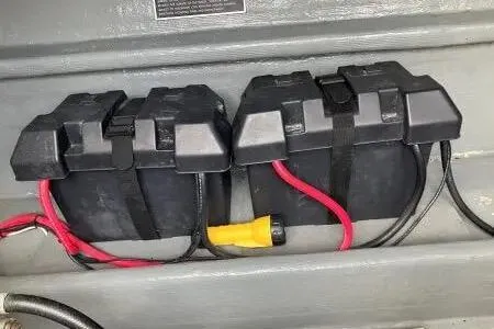 Slide: The Image of Dual battery setup in a 1996 Premium 28 Parasail boat, featuring secure black casings. - 15