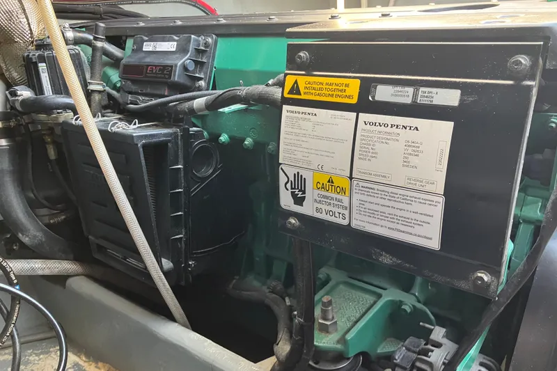 Slide: The Image of Engine compartment of a 1996 Premium 28 Parasail with Volvo Penta components and caution labels. - 19