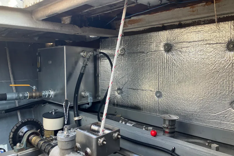 Slide: The Image of Engine compartment of a 1996 Premium 28 Parasail boat, featuring mechanical components and insulation. - 24