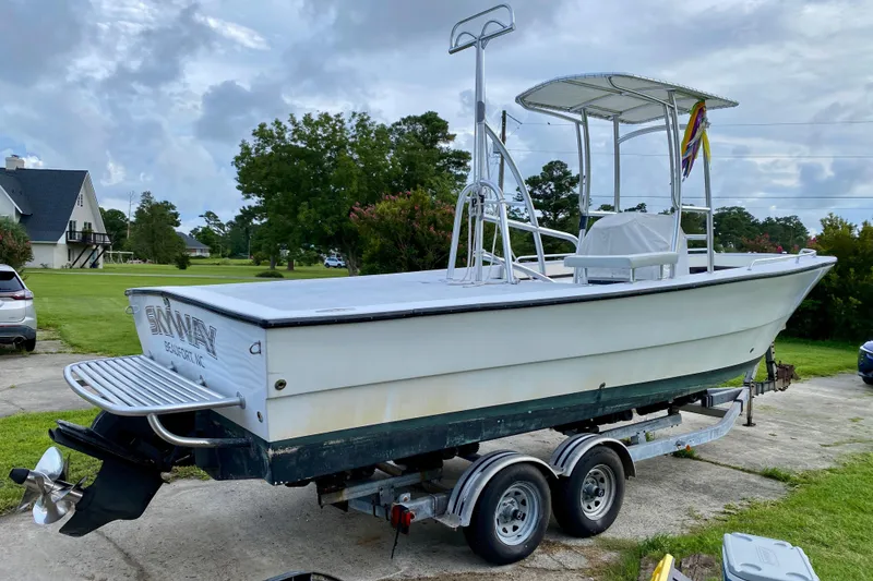 Slide: The Image of 1996 Premium 28 Parasail boat on trailer, parked outdoors with cloudy sky background. - 31