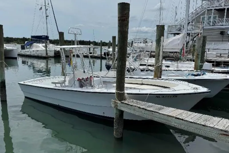 Slide: The Image of 1996 Premium 28 Parasail boat docked at marina with sailboats in background. - 3