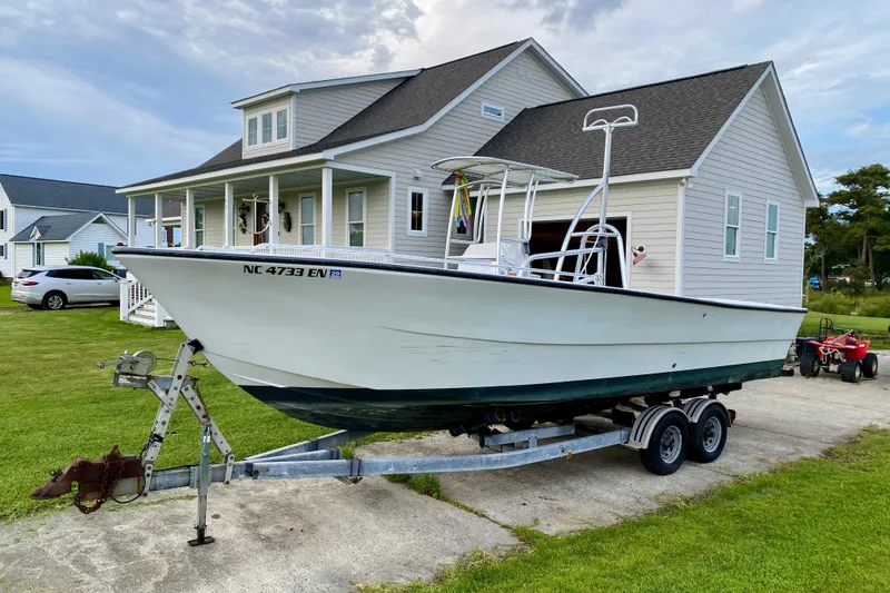 Slide: The Image of 1996 Premium 28 Parasail boat on trailer, parked in front of a house. - 33