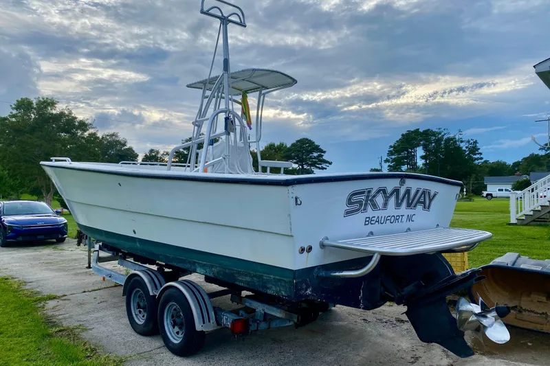 Slide: The Image of 1996 Premium 28 Parasail boat on trailer, labeled "Skyway Beaufort NC," under cloudy sky. - 32