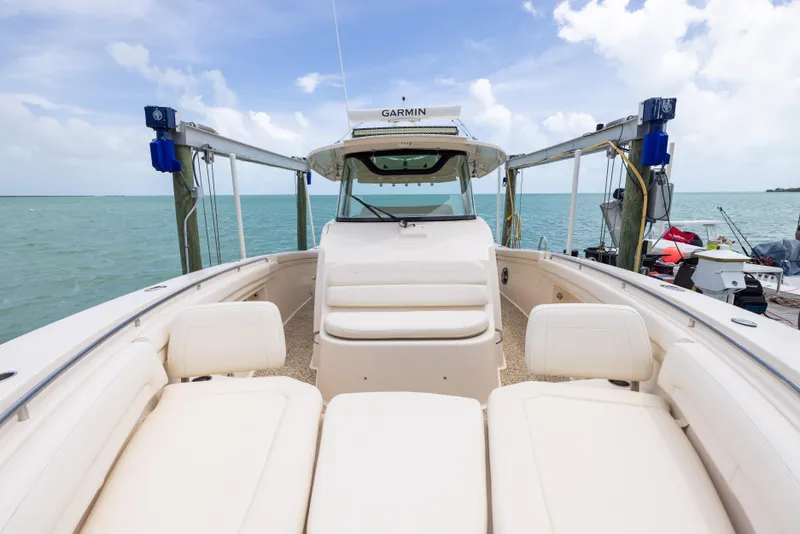 Slide: The Image of 2021 Grady-White Canyon 376 boat docked by the ocean under a cloudy sky. - 10