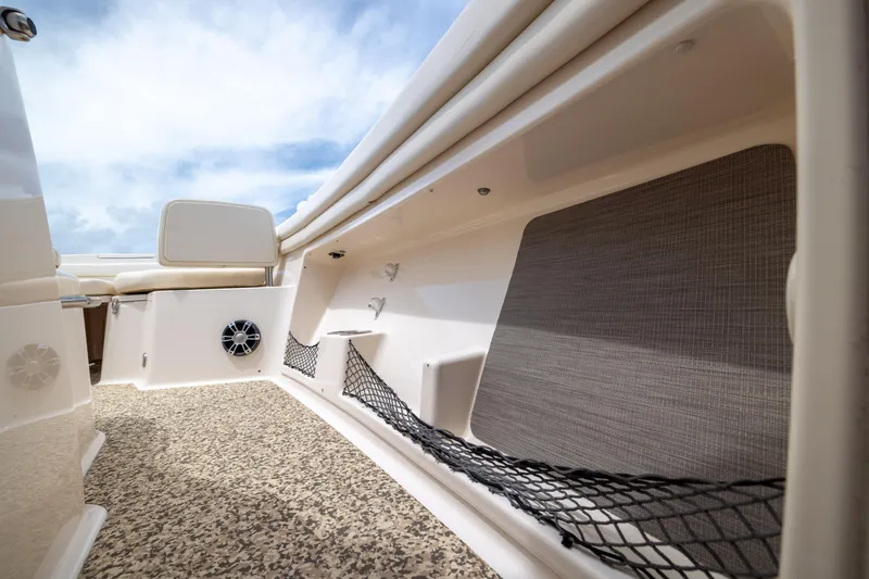 Slide: The Image of 2021 Grady-White Canyon 376 boat interior with storage nets and speaker, under a blue sky. - 12
