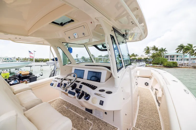Slide: The Image of 2021 Grady-White Canyon 376 boat interior with helm, steering wheel, and navigation screens. - 16