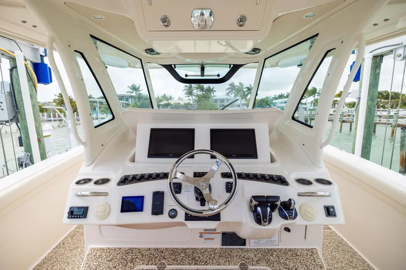 Slide: The Image of 2021 Grady-White Canyon 376 helm with dual screens and steering wheel, docked at marina. - 18