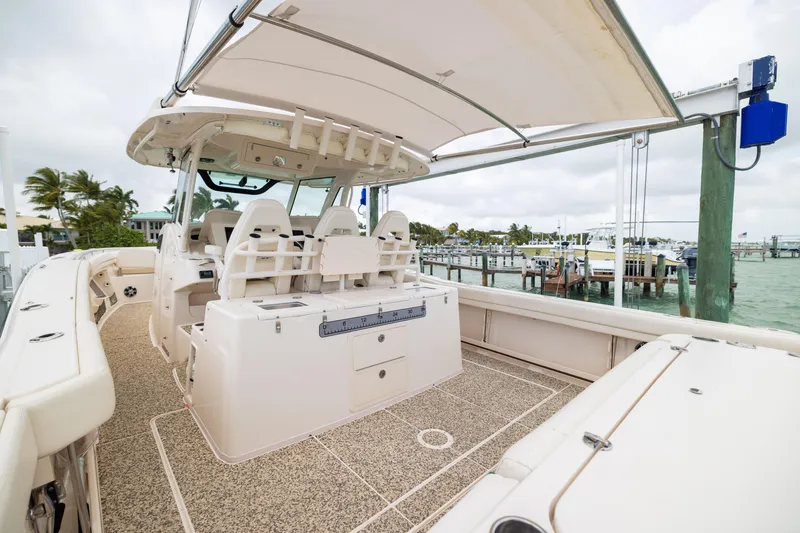 Slide: The Image of 2021 Grady-White Canyon 376 boat interior at marina, featuring spacious seating and fishing amenities. - 21