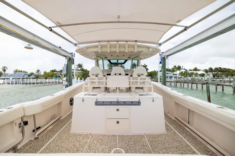 Slide: The Image of 2021 Grady-White Canyon 376 boat interior, featuring spacious seating and modern amenities at a marina. - 23