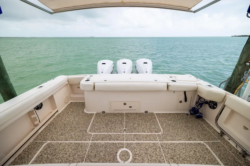 Slide: The Image of 2021 Grady-White Canyon 376 boat deck with triple engines, overlooking calm sea. - 26