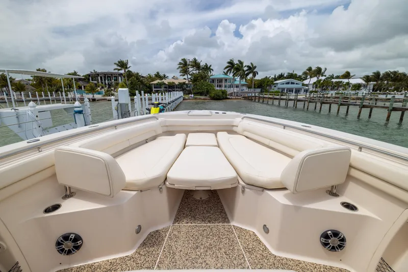 Slide: The Image of 2021 Grady-White Canyon 376 boat interior with plush seating, docked by waterfront homes. - 6