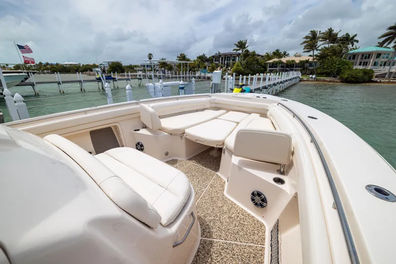 Slide: The Image of 2021 Grady-White Canyon 376 boat interior with plush seating at a marina. - 7