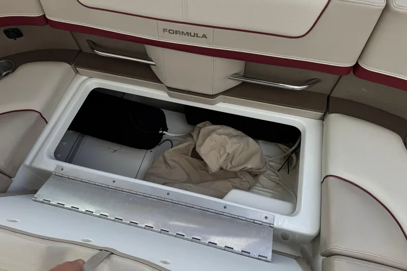 Slide: The Image of 2016 Formula 350 Crossover Bowrider I/O storage compartment with beige upholstery and metal handle. - 39