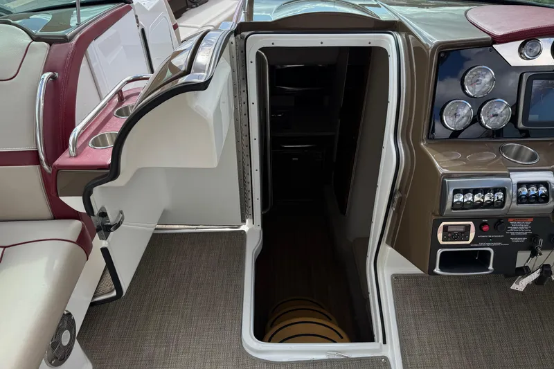 Slide: The Image of 2016 Formula 350 Crossover Bowrider I/O interior with open cabin door and dashboard controls. - 56